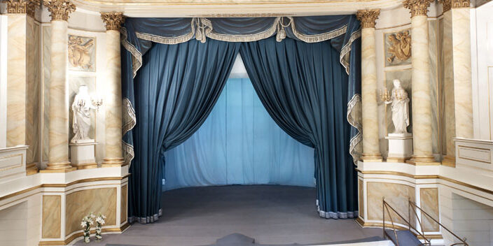 An ornately decorated room with a blue curtain.